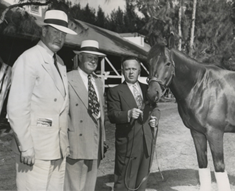 2003.12.390: Citation being held be trainer H. A. "Jimmy" Jones and with trainer Benjamin Jones and Captain Cecil Rochefort, Hialeah Park , January 1949 (Museum Collection)