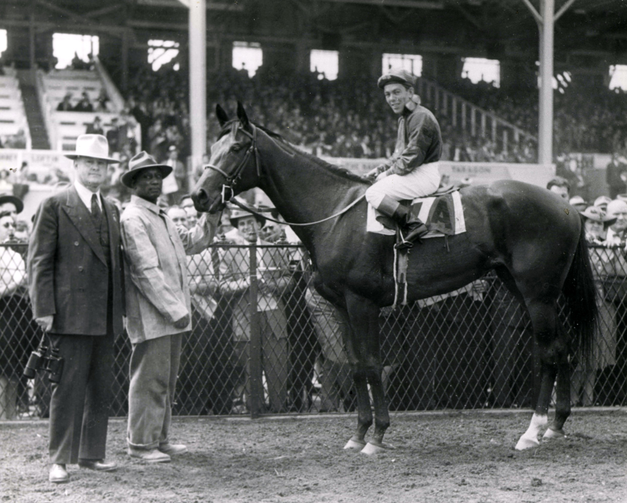 Twilight Tear (Conn McCreary up) in the winner's circle with trainer Ben Jones after winning the 1944 Rennert Handicap at Pimlico (The BloodHorse/Museum Collection)